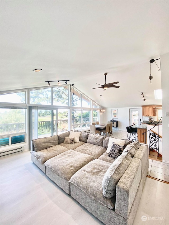 living room with baseboard heating, ceiling fan, and lofted ceiling