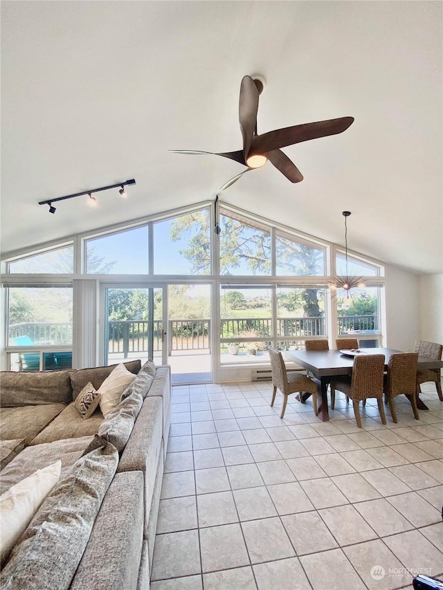 living room with lofted ceiling, ceiling fan, light tile patterned floors, and track lighting