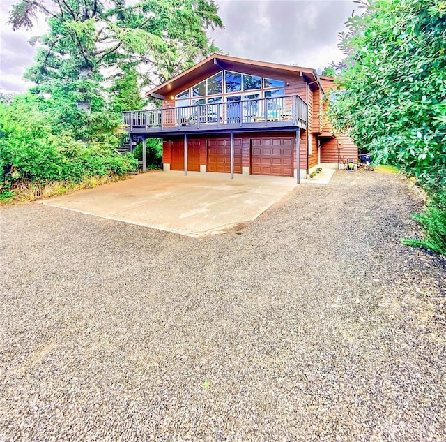 view of front facade featuring a garage and a wooden deck