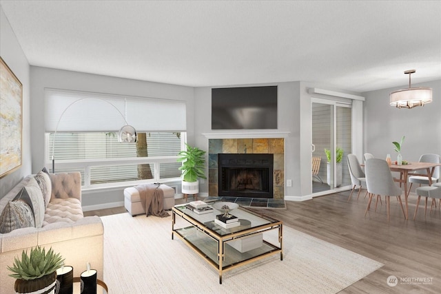 living room with wood-type flooring and a tile fireplace