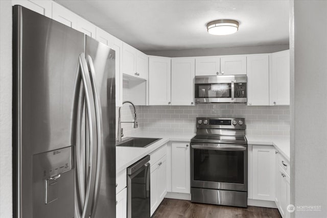 kitchen with backsplash, stainless steel appliances, sink, and white cabinets