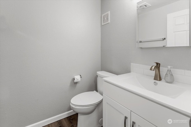 bathroom featuring vanity, wood-type flooring, and toilet