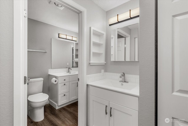 bathroom featuring hardwood / wood-style flooring, vanity, and toilet