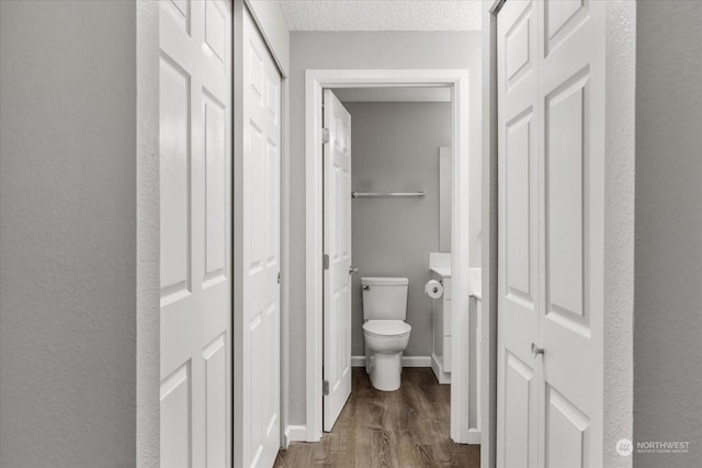 bathroom featuring hardwood / wood-style flooring, a textured ceiling, and toilet