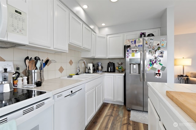 kitchen featuring sink, white appliances, white cabinets, and tile counters