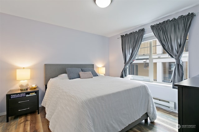 bedroom with dark hardwood / wood-style flooring and a baseboard radiator