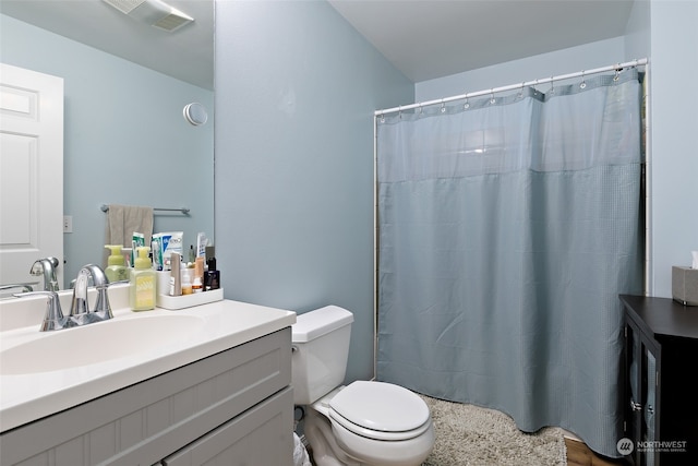 bathroom featuring toilet, curtained shower, and vanity