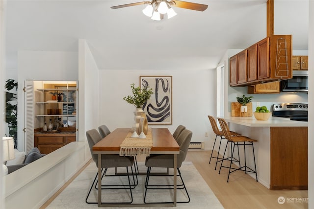 dining room featuring ceiling fan, light hardwood / wood-style floors, and a baseboard radiator