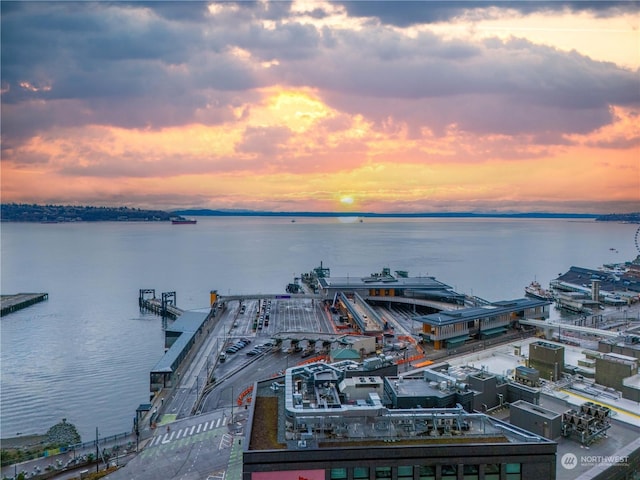 aerial view at dusk featuring a water view