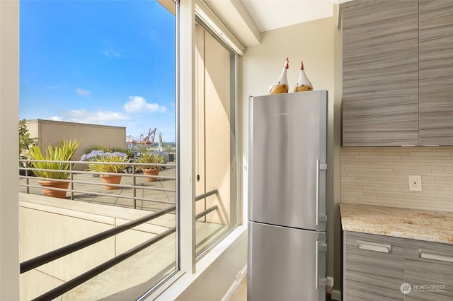 kitchen with backsplash and stainless steel refrigerator