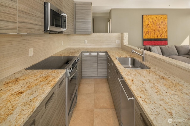 kitchen with sink, light tile patterned floors, tasteful backsplash, light stone counters, and stainless steel appliances