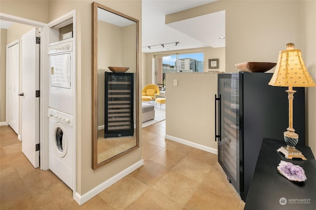 interior space featuring stacked washer / dryer, beverage cooler, and track lighting