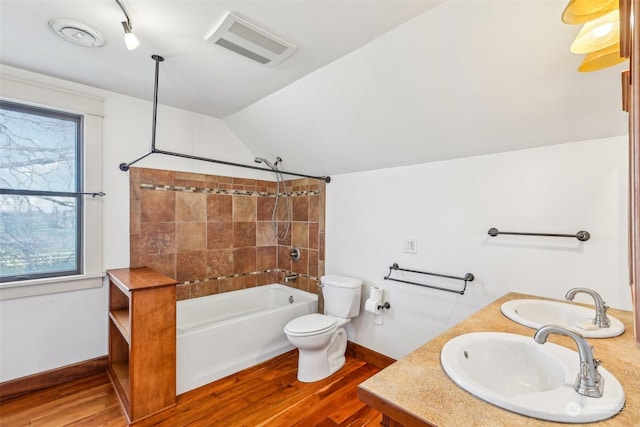 full bathroom featuring hardwood / wood-style flooring, plenty of natural light, lofted ceiling, and toilet