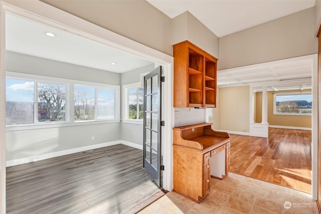 kitchen with decorative columns and light hardwood / wood-style flooring