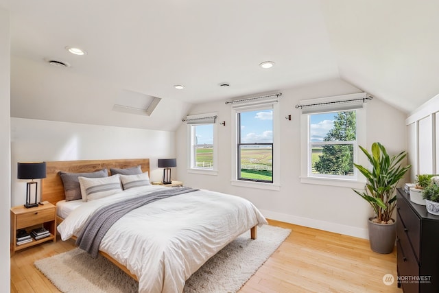 bedroom featuring light wood-type flooring and vaulted ceiling