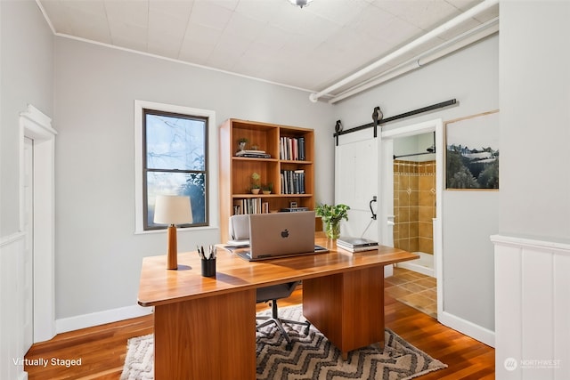 office area with a barn door and dark hardwood / wood-style floors