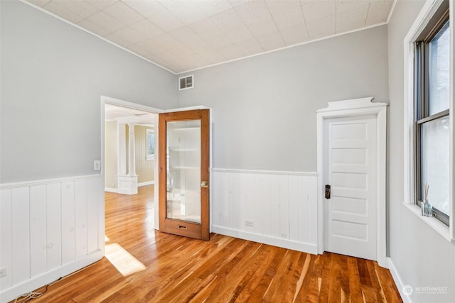 unfurnished room with hardwood / wood-style floors, french doors, and crown molding