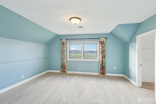 bonus room featuring light colored carpet and vaulted ceiling