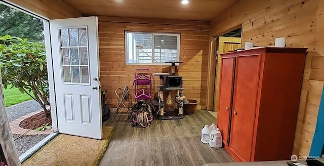 interior space with hardwood / wood-style floors, wooden ceiling, and wooden walls