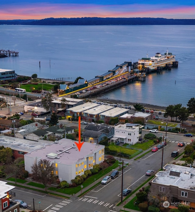 aerial view at dusk featuring a water view