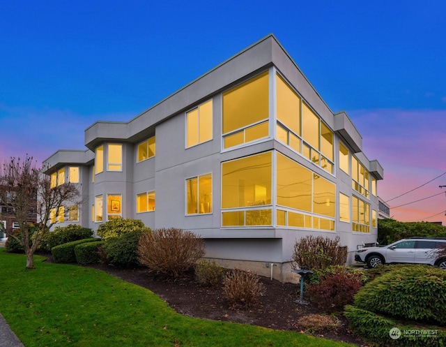 property exterior at dusk with a yard