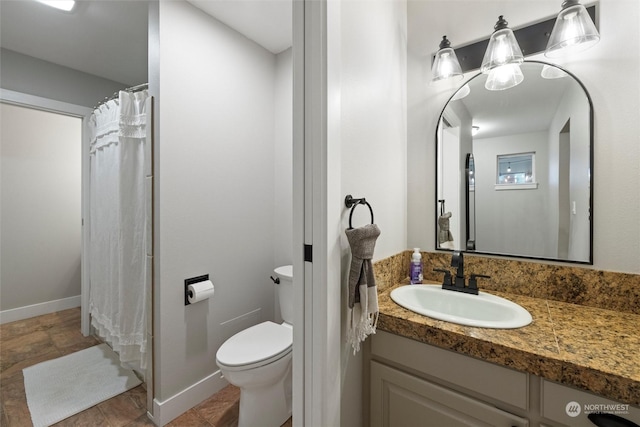 bathroom featuring a shower with shower curtain, vanity, and toilet