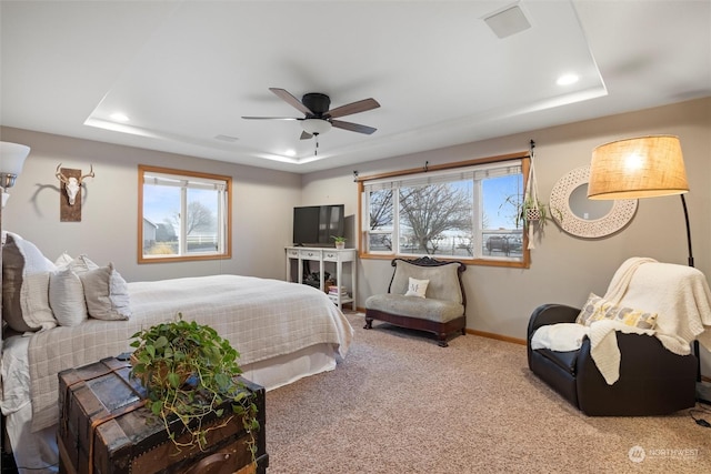 bedroom featuring carpet, a raised ceiling, and ceiling fan