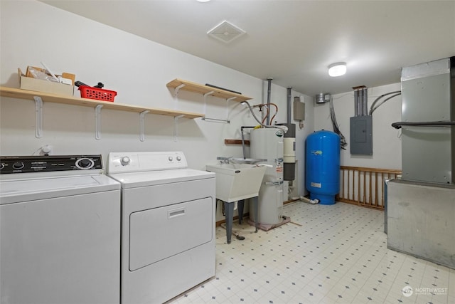 clothes washing area with electric water heater, electric panel, washer and clothes dryer, and sink