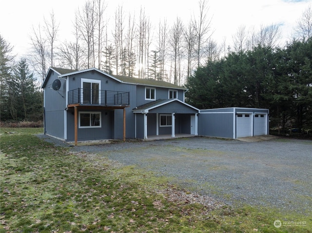 front facade with a garage, an outdoor structure, and a front yard