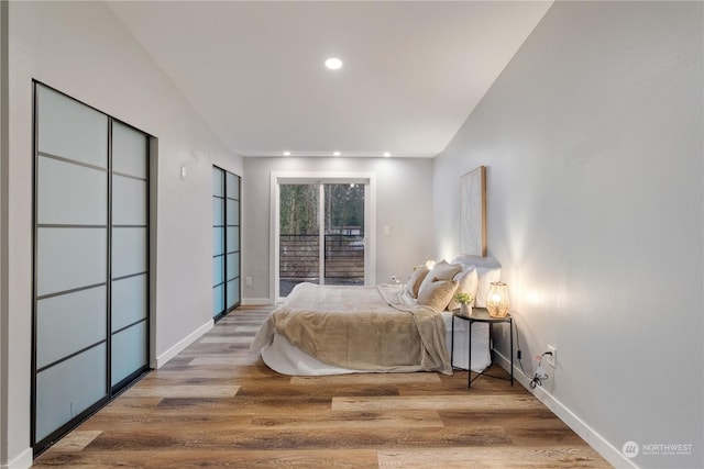 bedroom with access to outside and hardwood / wood-style flooring