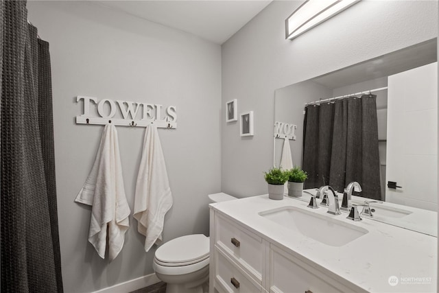 bathroom featuring vanity, toilet, and curtained shower