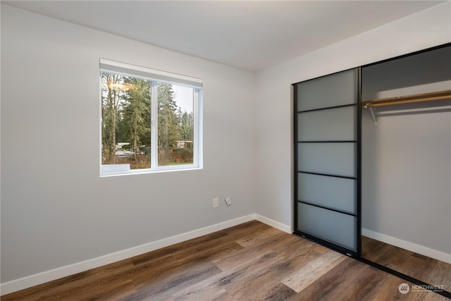 unfurnished bedroom with hardwood / wood-style flooring and a closet