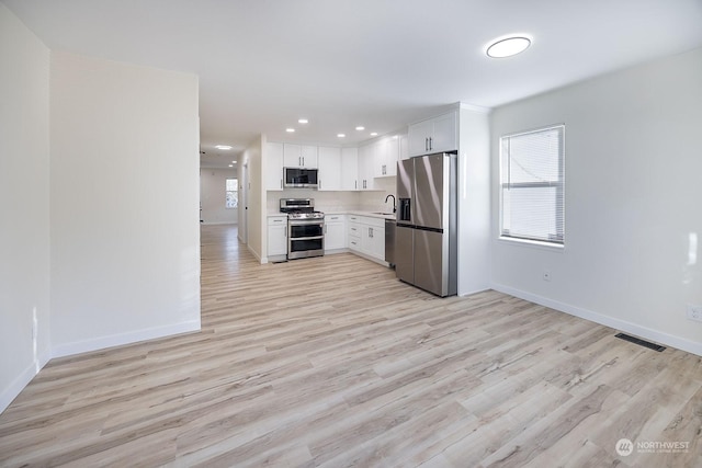 kitchen featuring white cabinetry, light hardwood / wood-style flooring, stainless steel appliances, and sink