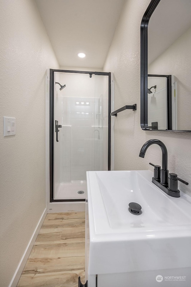 bathroom with sink, hardwood / wood-style floors, and walk in shower