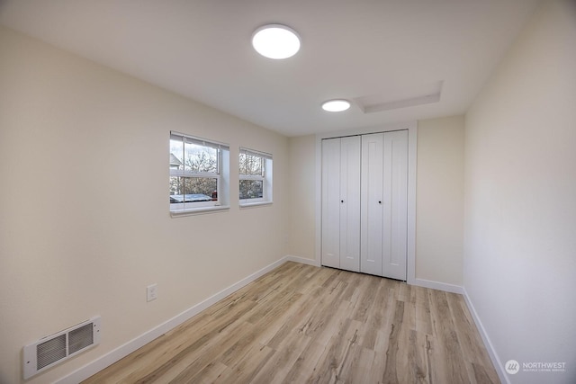 unfurnished bedroom with light hardwood / wood-style floors and a closet