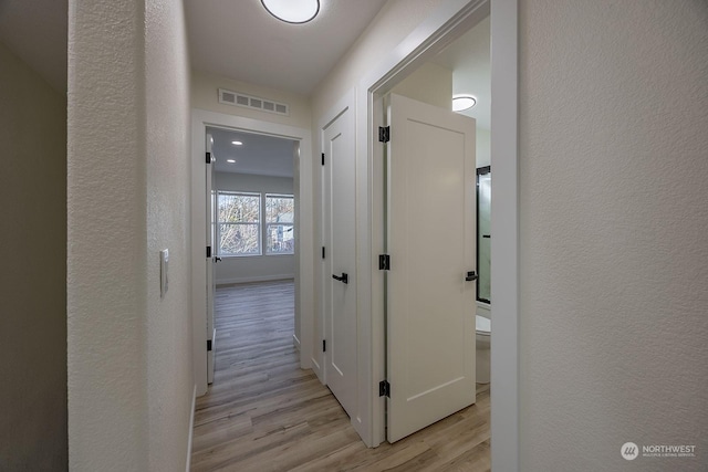 corridor with light wood-type flooring