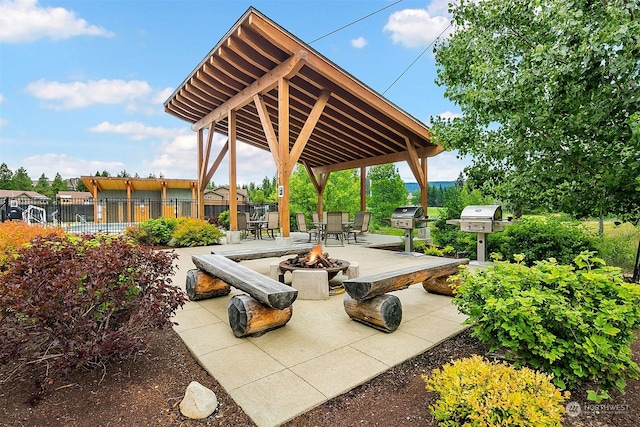 surrounding community featuring a gazebo and an outdoor fire pit