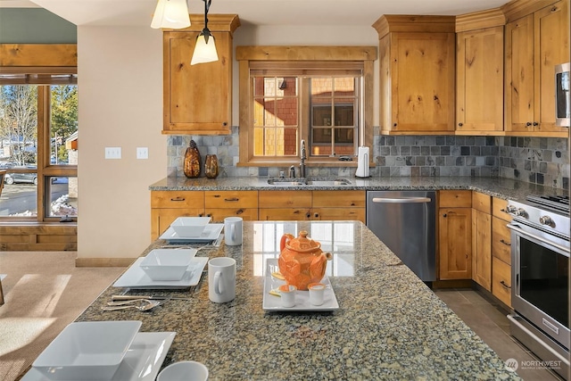 kitchen with decorative light fixtures, appliances with stainless steel finishes, decorative backsplash, and sink