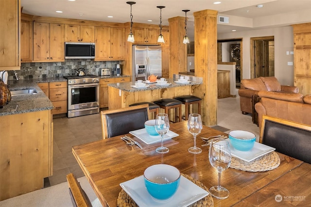 dining area featuring decorative columns and sink