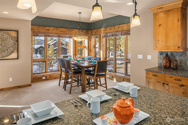 carpeted dining room featuring a chandelier