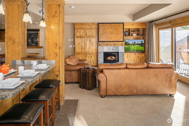 living room featuring built in features, a wealth of natural light, a fireplace, and dark carpet