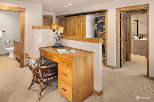 carpeted office space featuring stacked washer / drying machine