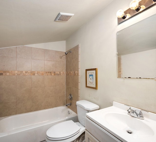 full bathroom featuring vanity, toilet, lofted ceiling, and tiled shower / bath combo