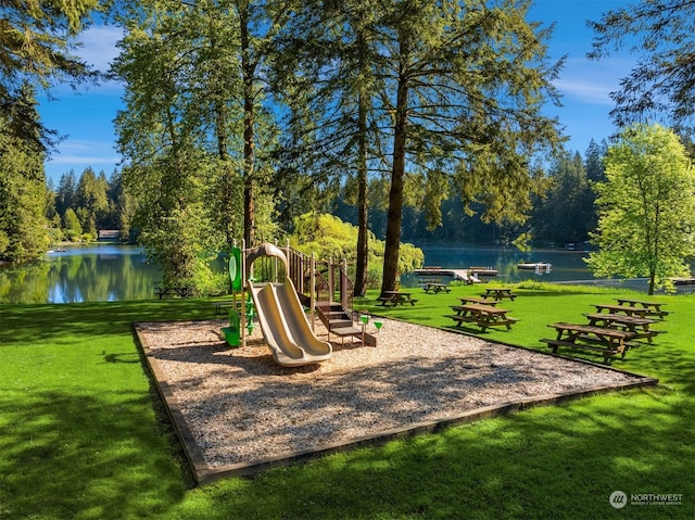 view of playground with a lawn and a water view