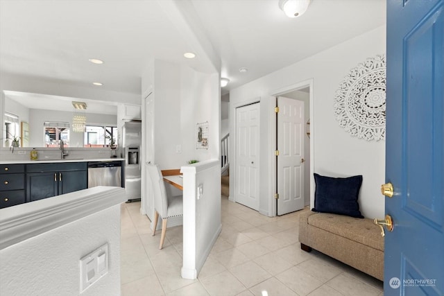 kitchen featuring stainless steel appliances, light tile patterned flooring, and sink