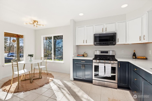 kitchen with white cabinetry, stainless steel appliances, light tile patterned floors, and plenty of natural light