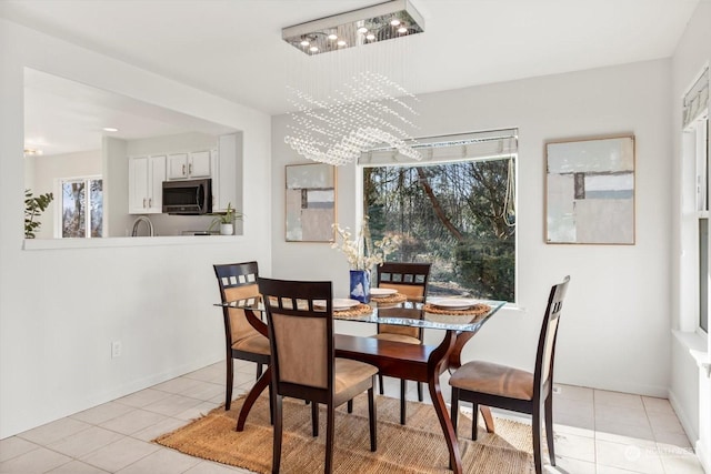 tiled dining area with an inviting chandelier and a healthy amount of sunlight