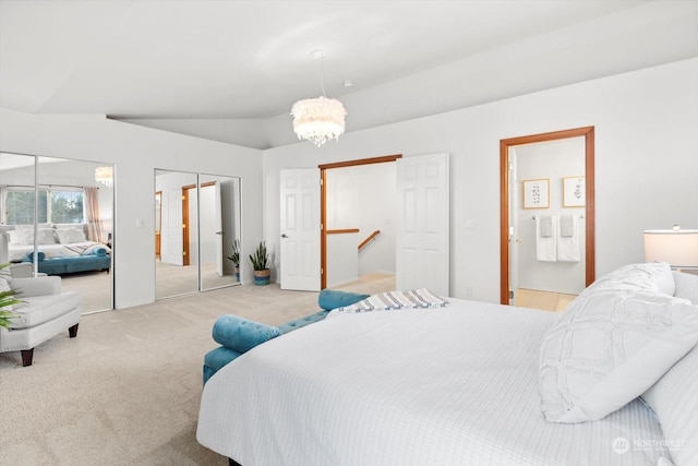 bedroom with a chandelier, vaulted ceiling, light carpet, and two closets