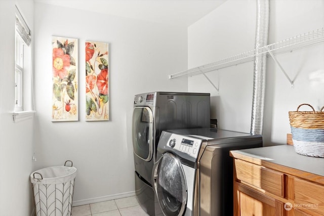 washroom featuring cabinets, washer and dryer, and light tile patterned floors