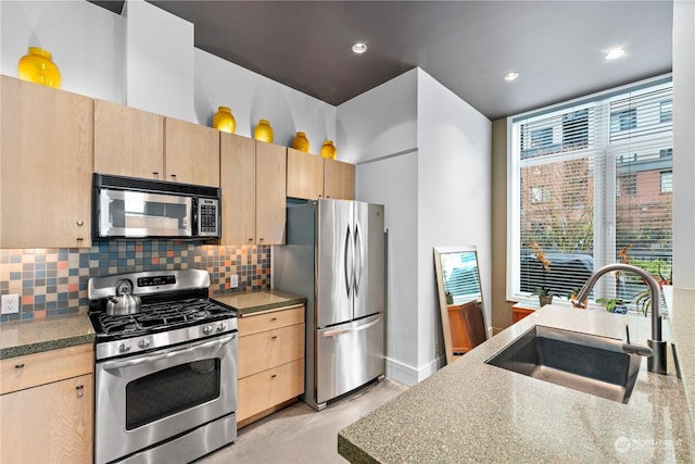 kitchen with backsplash, sink, stainless steel appliances, and light brown cabinetry